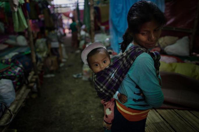 In this picture taken on May 11, 2018, an internally displaced woman and a child take temporary shelter in Danai, Kachin state. Photo: Ye Aung Thu/AFP
