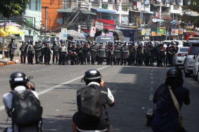 (File) Riot police advance on a street in Yangon as members of the press take photos during a protest against the military coup on February 26. Photo: EPA