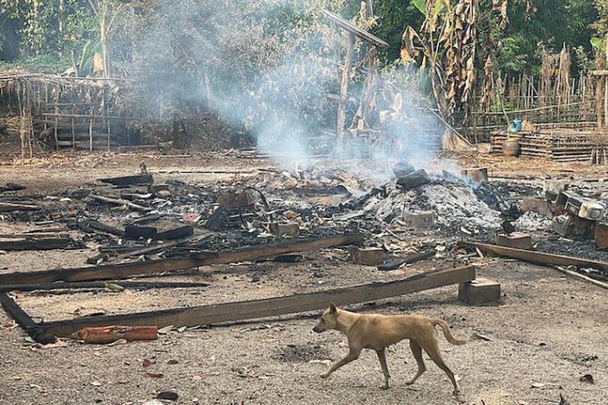 This handout photo from humanitarian group Free Burma Rangers taken on May 3, 2022 and released on May 4 shows a dog running past the burning remains of a building after airstrikes and mortar attacks by the Myanmar military, according to the Free Burma Rangers, on a village in Doo Tha Htoo district in Myanmar's eastern Kayin state. Photo: Free Burma Rangers/AFP