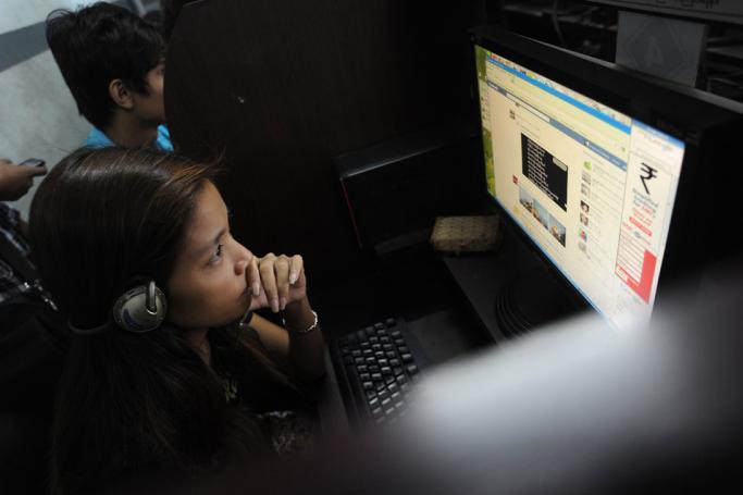 A woman browsing the internet at an internet cafe in Yangon. Photo: AFP