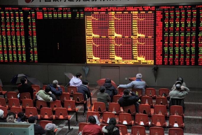 Investors watch stock prices at a securities exchange house in Shanghai, China. Photo: Qilai Shen/EPA
