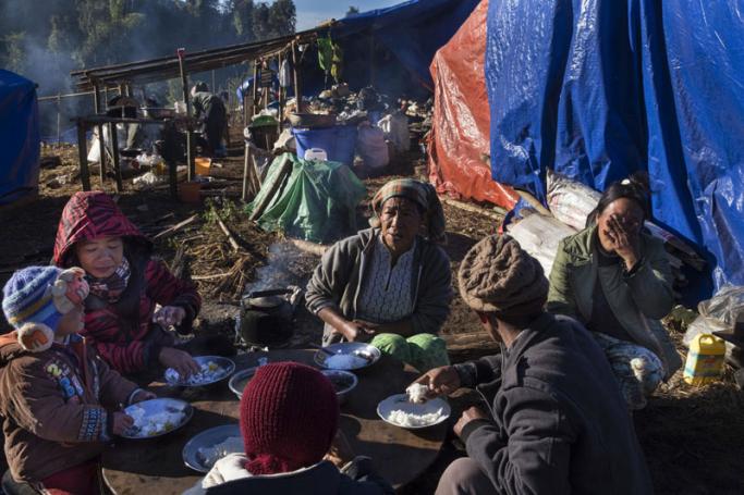 A Kachin refugee family eating near Lung Byeng village in Waimaw township in Kachin state. Photo: Hkun Lat/AFP
