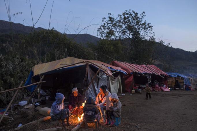 This photo is taken on January 21, 2017 shows a refugee family in front of their temporary shelter near Lung Byeng village, Waimaw township in Kachin state. Photo: Hkun Lat/AFP
