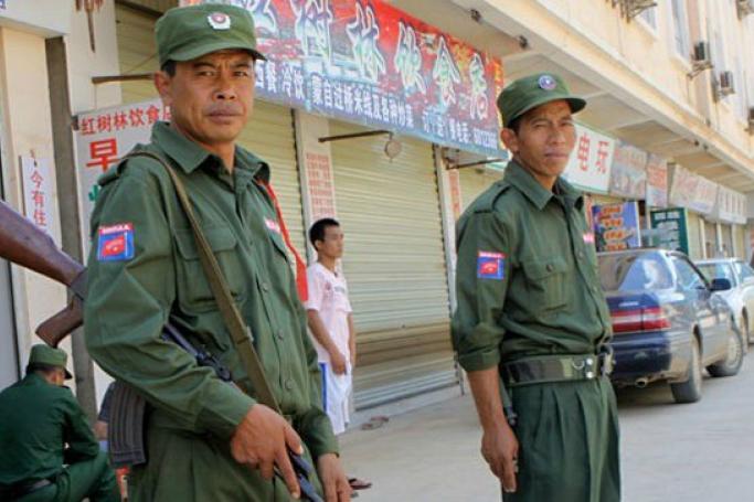 Kokang fighters are now calling for dialogue with the government. Kokang fighters standing outside a deserted market as a convoy carrying diplomats and journalists visit the Myanmar-China border town Laukkai, Myanmar on September 8, 2009. Photo: Khin Maung Win/EPA
