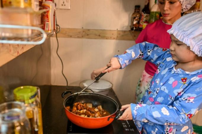  This photo taken on May 21, 2020 shows Moe Myint May Thu (R) and her mother Honey Cho cooking while filming a video at their house in Yangon. Photo: Ye Aung Thu/AFP
