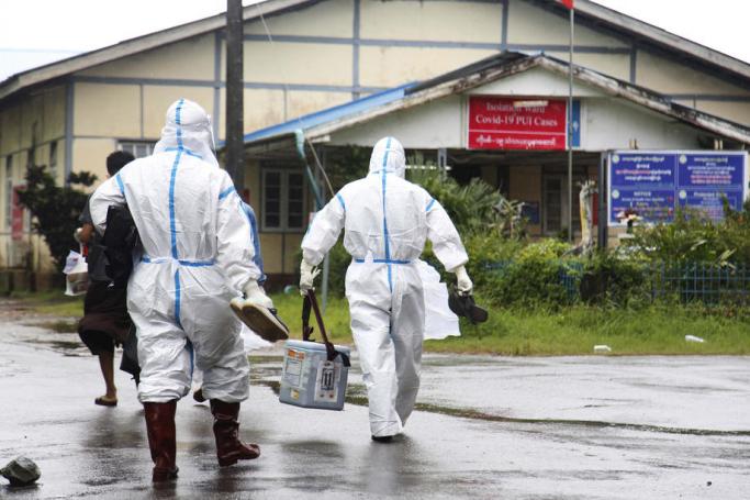 Medical workers wearing personnel wearing PPE (Personal protective equipment) walk towards the isolation ward of a hospital in Sittwe, Rakhine State, western Myanmar, 24 August 2020. Photo: Nyunt Win/EPA