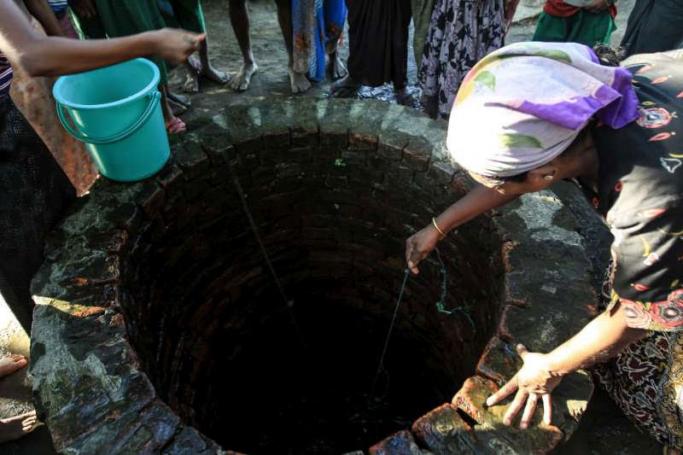 Looking for water in a well at the Thet Kay Pyin IDP camp near Sittwe. Photo: P.Behan/UNHCR
