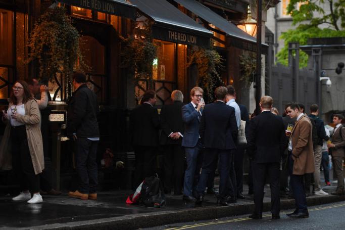 People enjoy a drink at a pub in London, Britain. Photo: EPA