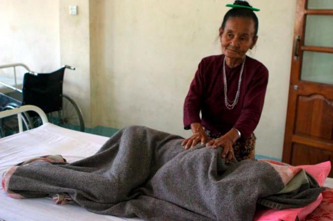 An elderly woman gives a massage to her daughter, who is a malaria patient at a hospital in the Ke Maunt area in Myanmar, December 20, 2006. Photo: LAW/EPA
