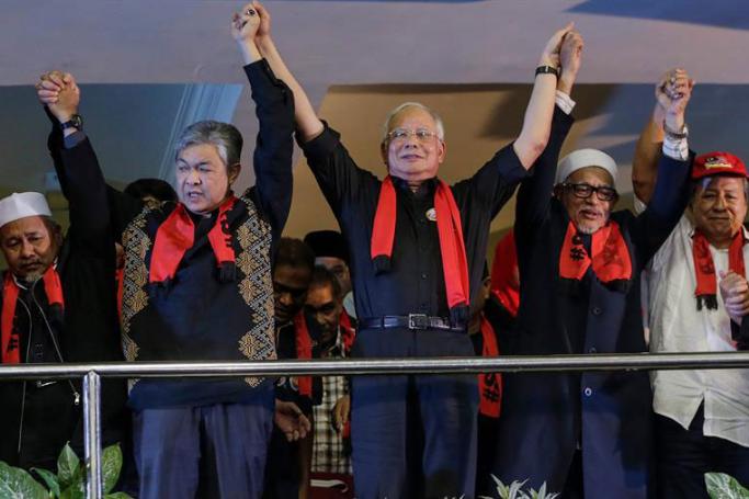 Malaysian Prime Minister Najib Razak (C), his deputy Zahid Hamidi (2-L) and opposition Pan Malaysian Islamic Party (PAS) president Abdul Hadi Awang (2-R) join hands during a protest condemning Myanmar's government violence on Rohingya people in Rakhine State, in Kuala Lumpur, Malaysia, 04 December 2016. Photo: Fazry Ismail/EPA
