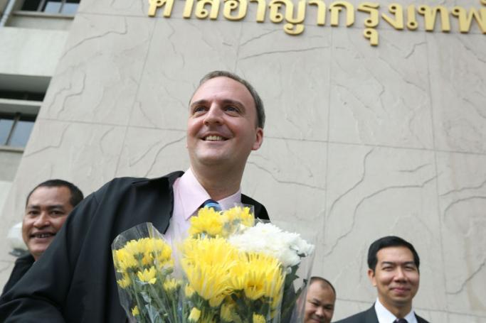 British lawyer and migrant workers' rights activist, Andy Hall poses for photo with flowers from supporters after he arrives for his trial on the official indictment in the charged over computer crimes and criminal defamation case at the Bangkok South Criminal Court in Bangkok, Thailand, 18 January 2016. Photo: Narong Sangnak/EPA
