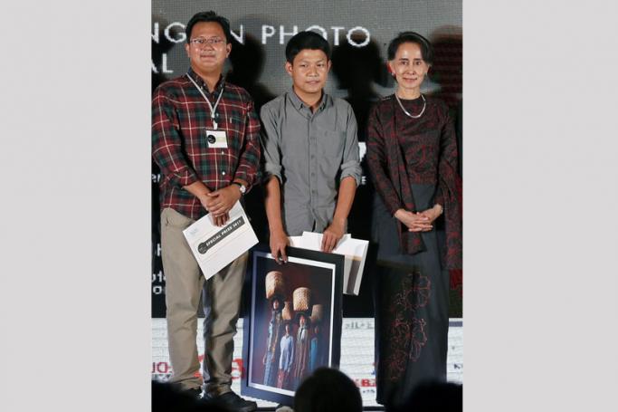 (FILE) - Photojournalists Min Zayar Oo (L) and Hkun Lat (C) pose for a photograph next to Myanmar's State Counselor Aung San Suu Kyi during the ninth Yangon Photo Festival at the Institut Francais de Birmanie School in Yangon, Myanmar, 11 March 2017. Photo: Nyein Chan Naing/EPA
