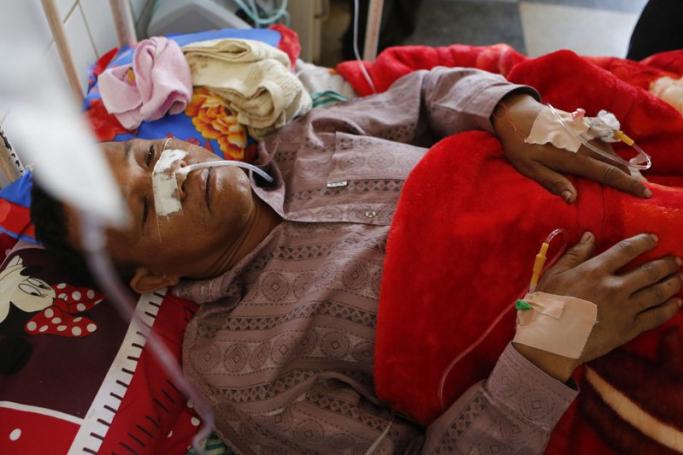 U Moe Kyaw Than, 47, volunteer of Myanmar Red Cross who was wounded in rescue convoy attack on 17 February, lies on bed at Lashio General Hospital, Lashio, northern Shan State, Myanmar, February 19, 2015. U Moe Kyaw Than reportedly died from his wounds on March 27. Photo: Lynn Bo Bo/EPA
