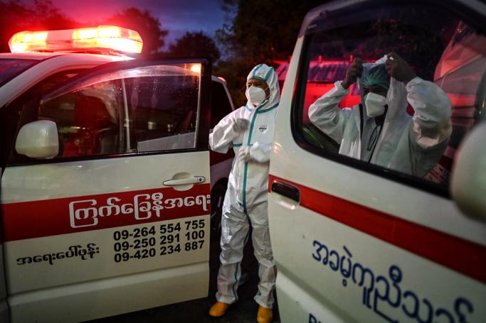 This photo taken on October 17, 2020 shows volunteers wearing personal protective equipment (PPE) waiting next to ambulances as they prepare to transfer local residents suspected of having the COVID-19 coronavirus to a quarantine centre in Yangon. Photo: Ye Aung Thu/AFP