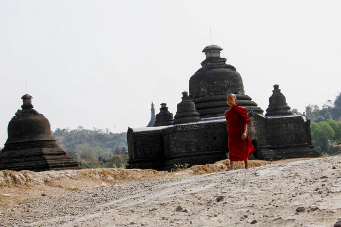 A young Buddhist novice walks past ancient pagodas at Mrauk U of Rakhine State, western Myanmar. Photo: Nyunt Win/EPA