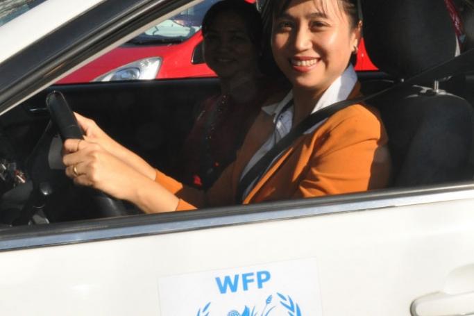 Ms Khin driving a WFP staff member to a meeting. Photo: WFP/Anna Zingg
