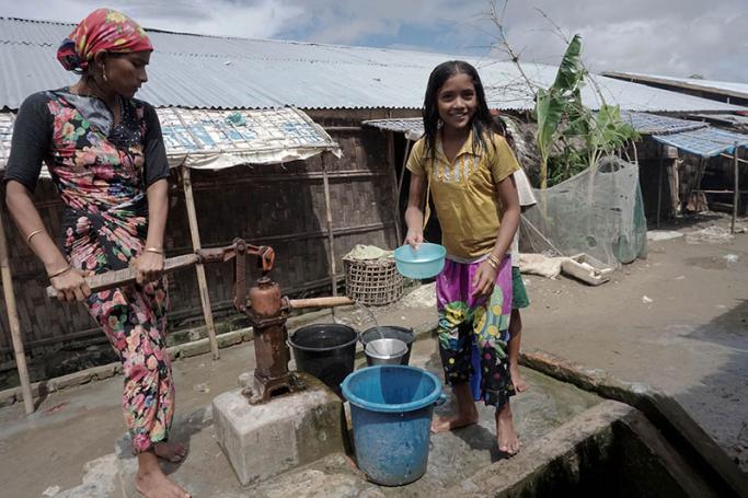 This photo is taken on 16 july, 2017 shows Muslim girls carrying water in Da Paing IDP camp near Sittwe town in Rakhine state. Photo: Hla Hla Htay/AFP
