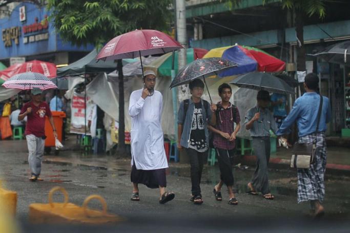 A Muslim man walks on a busy street in downtown Yangon. (Photo: Khun Lat, Myanmar Now) 
