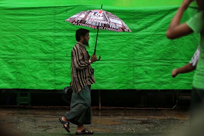 Muslim man walks on a busy street in downtown Yangon. Photo: Khun Lat, Myanmar Now 
