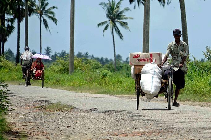 Muslim people on trishaws transit near Muslim Internally Displaced Persons (IDPs) camps in Sittwe, Rakhine State, western Myanmar, 29 August 2017. Photo: Nyunt Win/EPA
