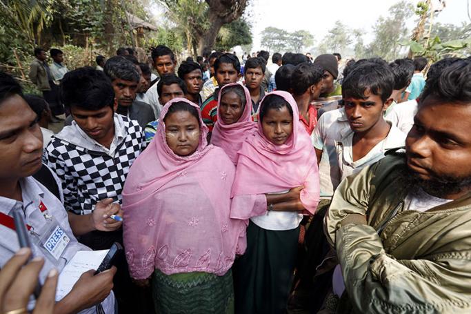Muslim people talk to media at the Pyaung Bate village which was burnt down during the conflict near the Maungdaw town of Bangladesh-Myanmar border, Rakhine State, western Myanmar, 21 December 2016. Photo: Nyein Chan Naing/EPA
