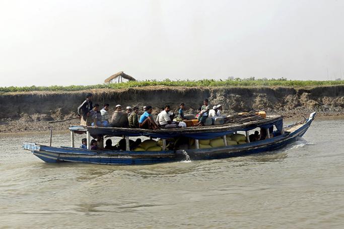 (File) Muslim people travelling by boat on Naf river near ButheeTaung town, Rakhine State, western Myanmar, 20 December 2016. Photo: Nyein Chan Naing/EPA
