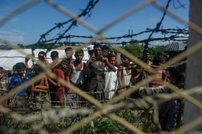 Rohingya refugees gather near the fence in the "no man's land" between Myanmar and Bangladesh border as seen from Maungdaw, Rakhine state, on June 29, 2018. Photo: Phyo Hein Kyaw/AFP
