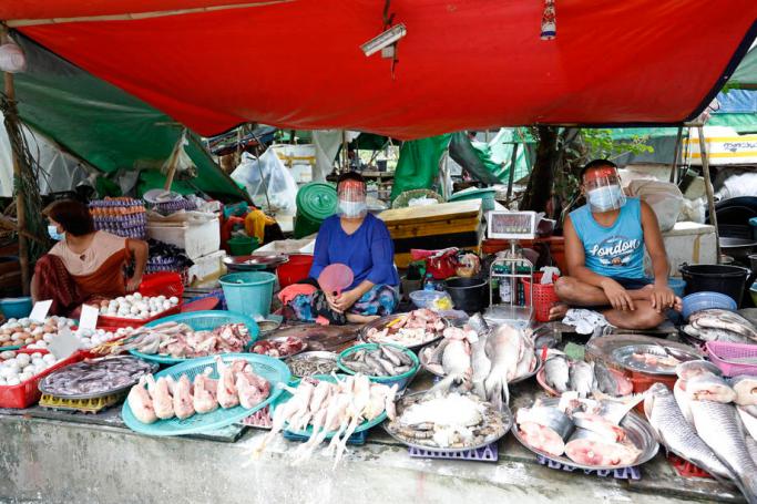 Vendors wear face shields and mask as they sell fresh meat at a market in Yangon, Myanmar, 22 October 2020. Photo: Nyein Chan Naing/EPA