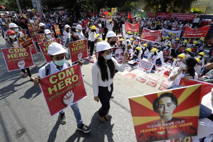 Demonstrators hold placards calling for the release of detained State Counselor Aung San Suu Kyi and to support the Civil Disobedience Movement (CDM) during a protest against the military coup outside the Chinese embassy in Yangon, Myanmar, 14 February 2021. Photo: Lynn Bo Bo/EPA