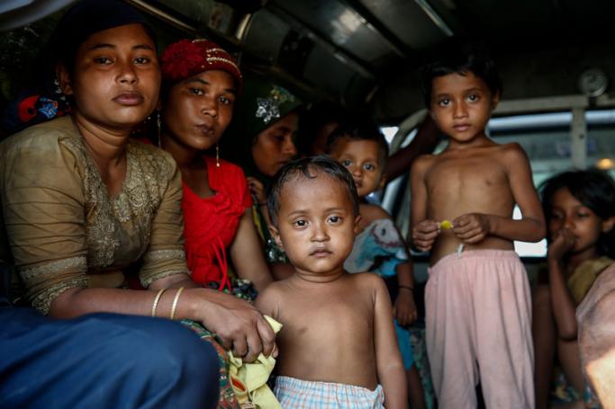 Rohingya women and children sit in a light truck as authorities move them to the KyaukTan township, south of Yangon, Myanmar, 16 November 2018. Photo: Lynn Bo Bo/EPA
