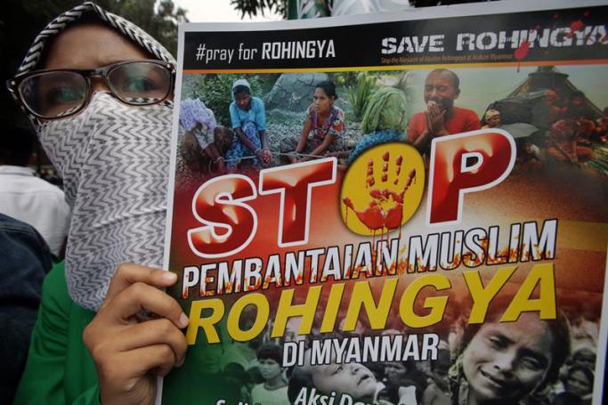 An Indonesian student holds a poster, reading 'Pray for Rohingya', 'Save Rohingya', 'Stop Genocide Rohingya in Myanmar' and 'Arrested and prosecuted the Genocide of Rohingya', during a protest in front of the Myanmar Embassy in Jakarta, Indonesia, 25 November 2016. Photo: Bagus Indahono/EPA
