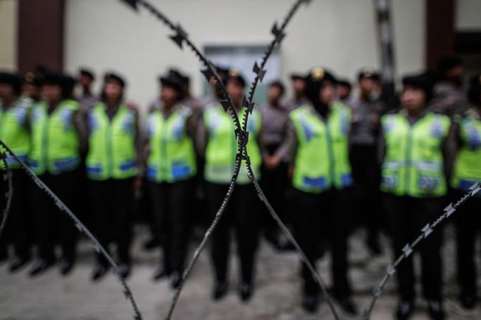 Indonesian police officers stand guard behind barb wire during a protest outside the Myanmar Embassy in Jakarta, Indonesia, 25 November 2016. Photo: EPA
