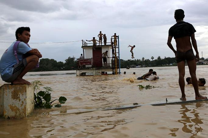 People playing in floodwaters in Pathein of Ayeyarwaddy Region, Myanmar, 12 August 2015. Photo: Lynn Bo Bo/EPA

