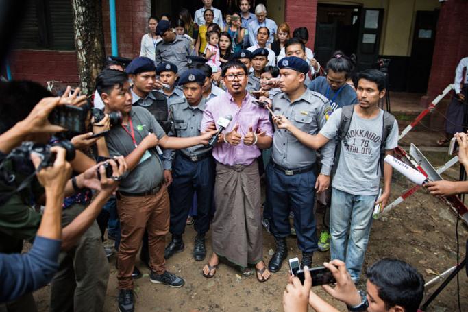 Detained Reuters journalist Wa Lone (C) talks to media while being escorted by police as he leaves the court after his trial hearing in Yangon, Myanmar, 02 July 2018. Photo: Lynn Bo Bo/EPA-EFE
