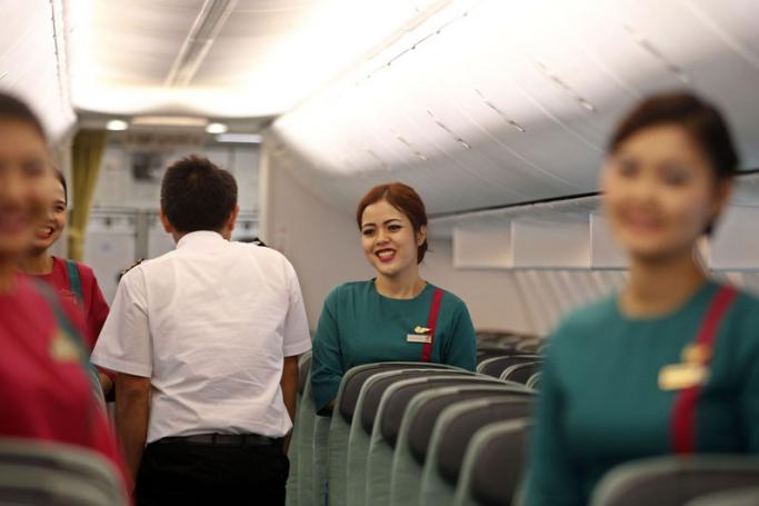 Cabin crew, including flight attendands, inside Myanmar National Airlines' first flight, a Boeing 737-800, after touchdown at Yangon International Airport, Yangon, Myanmar, 15 June 2015. Photo: Nyein Chan Nyein/EPA
