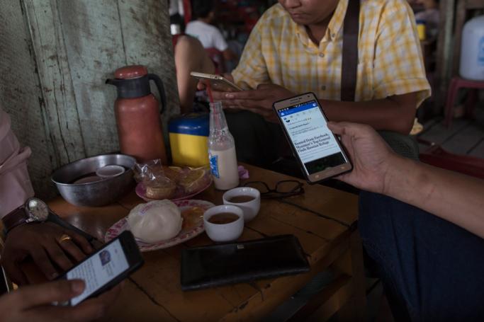 Myanmar people gather for refreshement at a teashop in Yangon many hangout to chat and browse facebook with their mobile phone. Photo: Sai Aung Main/AFP