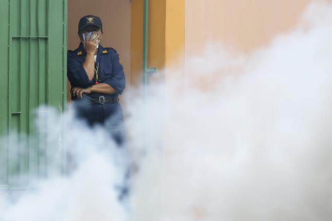 A Thai security guard covers her face as Thai health officials spray chemicals to kill mosquitos in Sathon district in Bangkok to combat the Zika virus. At least 21 Zika virus cases were reported, including a pregnant woman, in the Sathon district and nearby districts of central Bangkok. Fears are that the virus will spread to Myanmar. Photo: EPA
