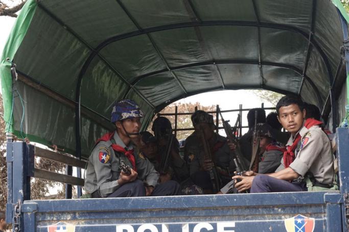 Myanmar policemen sit in the back of a police truck as they ride past Myo Thu Gyi Muslim village where houses were burnt to the ground near Maungdaw town in northern Rakhine State on August 31, 2017. Photo: AFP
