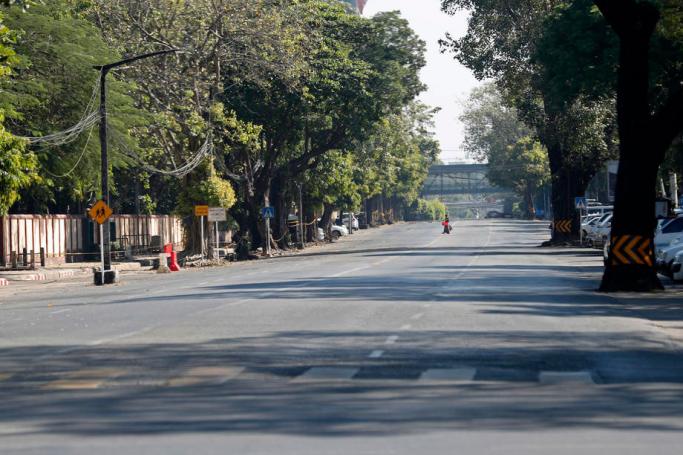 A woman crosses the empty street in downtown Yangon, Myanmar, 10 December 2021. Photo: EPA