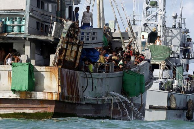 A picture made available on 01 June 2015 shows the boat of migrants (L) attached to a Myanmar Navy vessel anchored near the Thameehla island, Irrawaddy division, Myanmar, 31 May 2015. Photo: EPA
