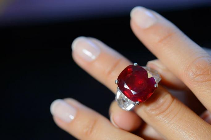 A Sotheby's employee shows a ruby and diamond ring by Cartier, with a Myanmar ruby weighing 25.59 carats, during a preview at the Sotheby's in Geneva, Switzerland, 06 May 2015. Photo: Martial Trezzina/EPA

