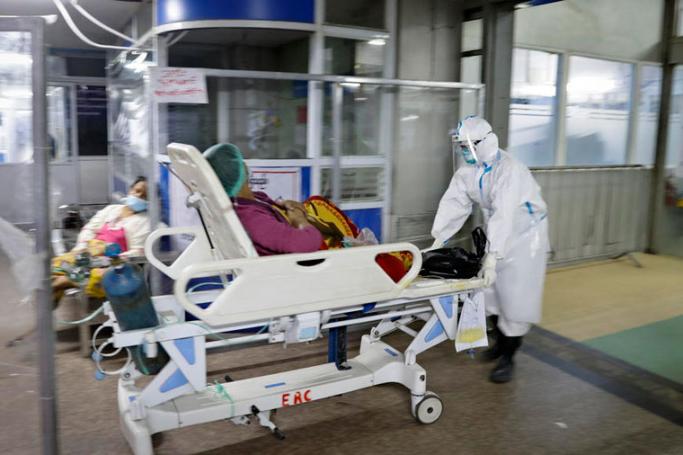  A medical worker wearing PPE (personal protective equipment) moves a patient into COVID-19 cases management zone at the emergency department at Yangon General Hospital, in Yangon, Myanmar, 01 January 2021. Photo: EPA