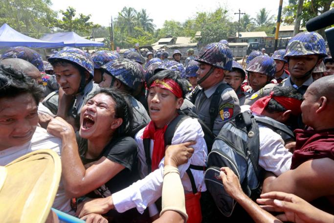 Student protesters and Buddhist monks jostle with police at barricades set up by police at the students protest site in Letpadan, Bago division, about 145 kilometres north of Yangon, Myanmar, 10 March 2015. Photo: Nyein Chan Naing/EPA
