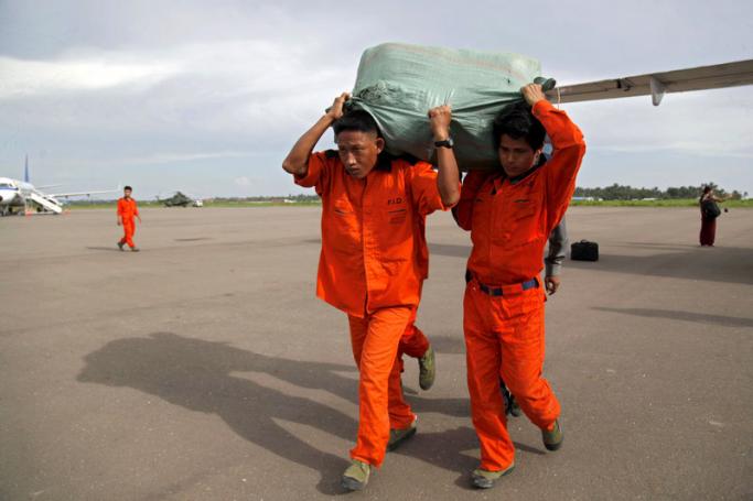 (File) Rescue workers carry the relief aid for flood victims at the Sittwe airport in Sittwe, Rakhine State. Photo: EPA