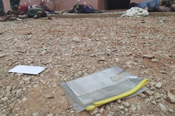 Census forms inside a plastic envelope can be seen near bodies lying on the ground of a Buddhist monastery in Nam Nein village, Pinlaung township, Shan state, eastern Myanmar on March 12, 2023. Photo: Pa-Oh National Defense Force-Kham Koung
