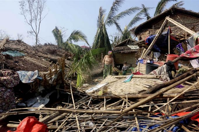 A Rohingya woman stands near a damaged house at the Thae Chaung Muslim internally displaced people (IDPs) camp near Sittwe, Rakhine State, Myanmar, 17 May 2023. Photo: EPA