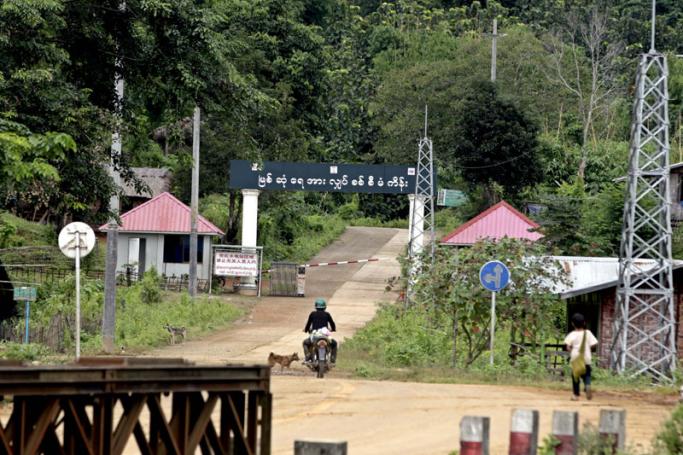 A motobiker riding past the entrance of the Myitsone dam project in Myitkyina, Kachin State, Myanmar. Photo: Nyein Chan Naing/EPA