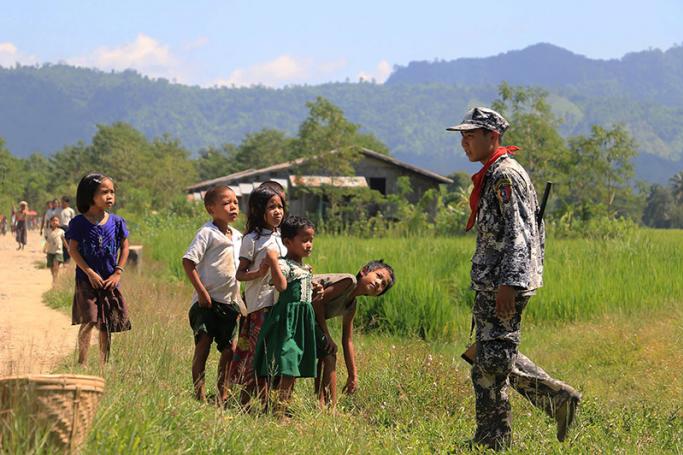 Myo ethnic children looks at a Myanmar border police in LaungDon, located in Rakhine State. Photo: AFP
