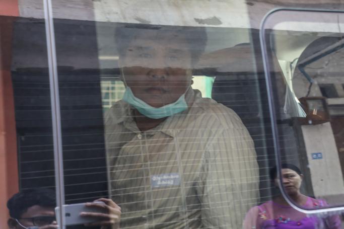 Voice of Myanmar (VOM) editor-in-chief Nay Myo Lin (C) sits in a vehicle as he is escorted from his home by the police to court in Mandalay on March 31, 2020. Photo: Zaw Zaw/AFP