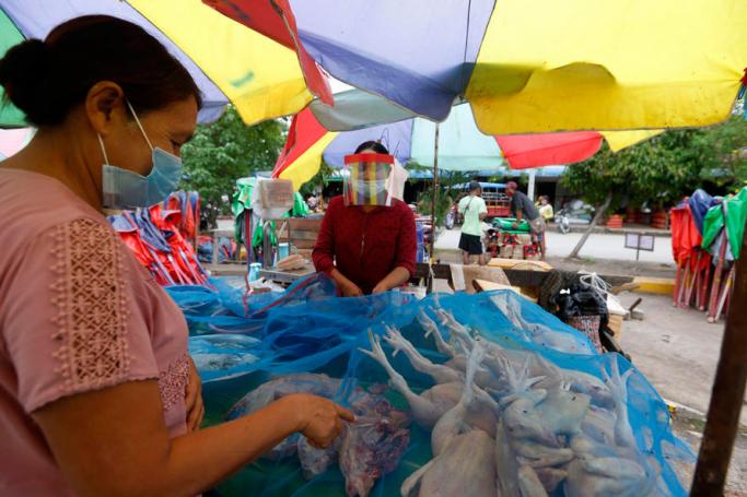 (File) A vendor wears face shield as she sells chicken to a customer at a market in Naypyitaw, Myanmar, 19 June 2020. Photo: Nyein Chan Naing/EPA
